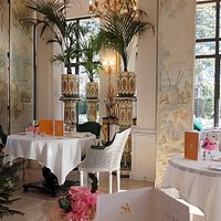 Salle de restaurant" Villa Saint Ange" baignée de lumière tables rondes joliment dressée