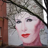 „Wysokie Obcasy” tworzą szlak murali portretujących wyjątkowe kobiety, które zmieniły historię regionu, Polski czy świata. Mural z wizerunkiem Kory autorstwa Bruno Althamera powstał w ramach akcji "Kobiety na mury" na ścianie Warszawskiej kamienicy przy ulicy Nowy Świat 18/20 (na tyłach Pałacu Branickich). Więcej o szlaku muralowym "Wysokich Obcasów" na stronie: wysokieobcasy.pl/kobietynamury