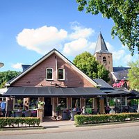 Naast de kerk met een lekker terras rondom. Altijd wel een plekje in de schaduw of juist in de zon.