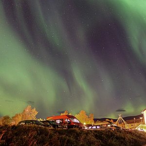 The northern lights above Abisko Guesthouse (the hotel is the yellow building bottom right). 