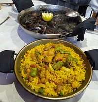 En primer plano una ración de paella valenciana, en segundo plano "dos" raciones de arroz con chipirones . Y pongo entre comillas lo de dos raciones porque pueden comer bien tres personas.