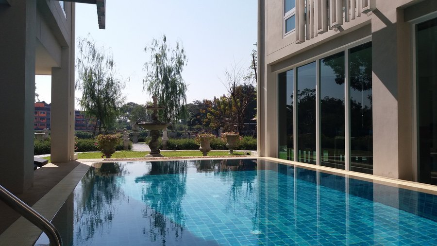 Outdoor swimming pool between the breakfast restaurant and the reading room with pretty garden and river in the background
