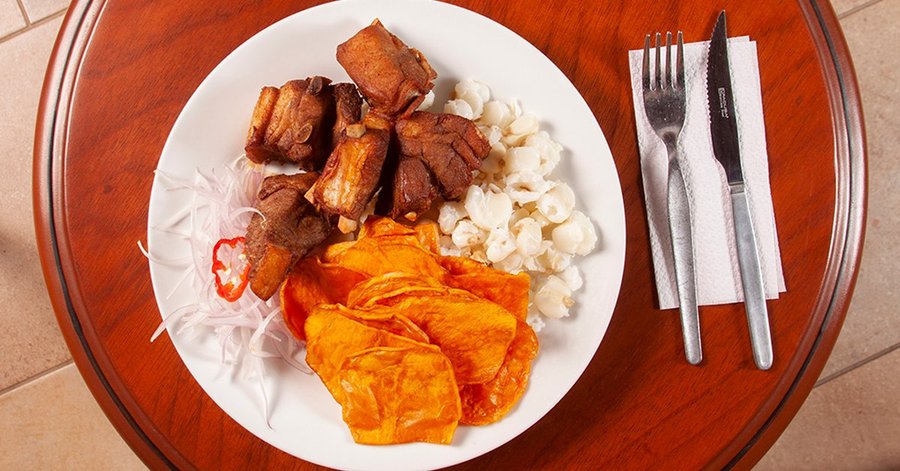 Delicioso y tradicional chicharrón acompañado de camote frito, mote y sarza criolla.