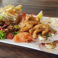Seafood platter for 2 includes panfried fresh local fish, Hervey Bay scallops, prawns, calamari, smoked salmon, fresh salad and a side of chips