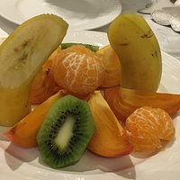 Plat de fruits très bien présentés avec clémentine banane kiwi kaki