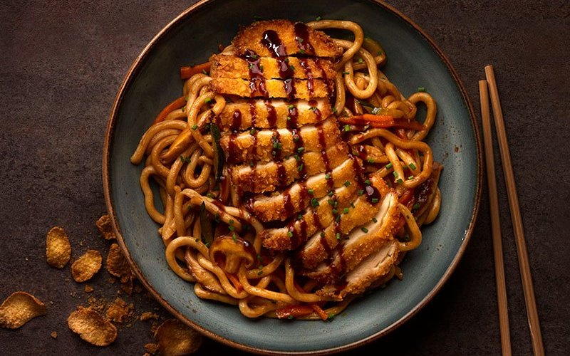 Corral Chicken Yaki Udon
Yaki Udon salteados con setas shiitake, zanahoria, calabacín, brotes de soja y pechuga de pollo de corral rebozada con Corn Flakes® crujientes y salsa yakisoba