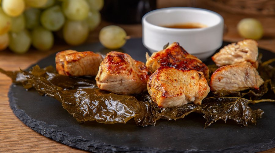 Шашлык из идичкы на виноградных листьях с соусом ткемали / Turkey skewers served on grape leaves with cherry tomato sauce