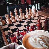 para las personas que gustan jugar al ajedrez cuentan con varios tableros en la mesa, para que jugar mientras disfrutas de un delicioso café