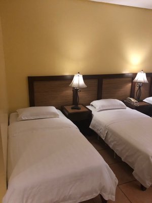 Planta Centro Bacolod Hotel & Residences in Negros Island, image may contain: Lamp, Bed, Hotel, Table Lamp