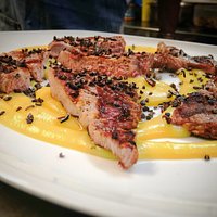 Coppa di suino Duroc d'Olives servita su un cremoso di patate affumicate al grue di cacao.