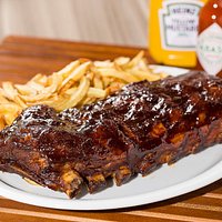 Ribs Barbecue - Deliciosa costela suína assada lentamente em baixa temperatura banhada com molho barbecue e acompanhada de batatas fritas tradicional.