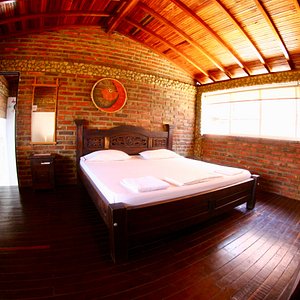 Habitación con piso en madera y cama king size. Muy comoda y tranquila.