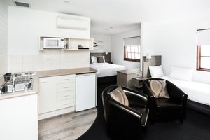 Bay Hotel Apartments in Hobart, image may contain: Chair, Furniture, Indoors, Lamp