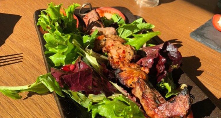 Chicken skewer on a bed of salad