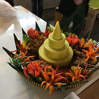The famous nasi kuning tumpeng served on bamboo woven round tampah