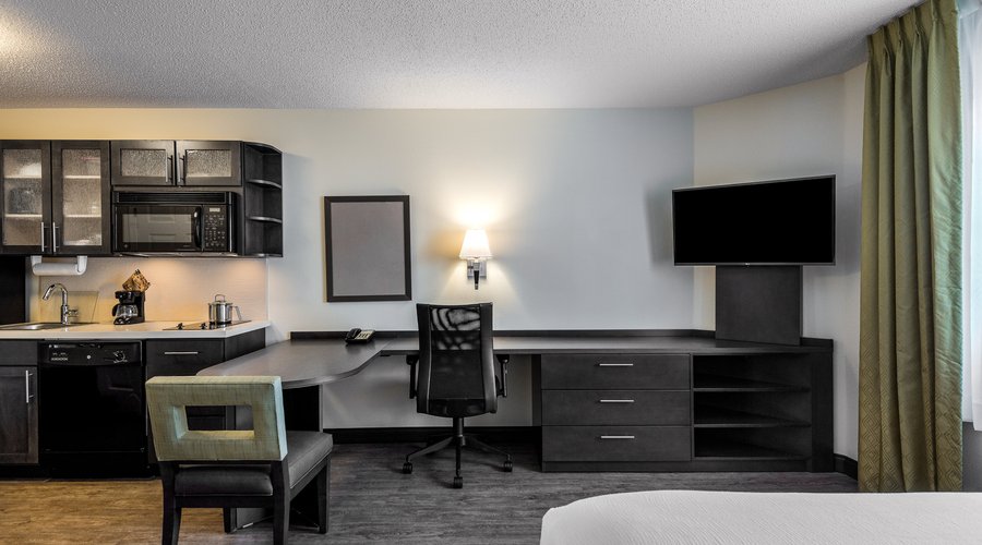 Studio Suite with fully equipped kitchen, spacious dining and desk area, and queen size bed.