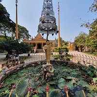 Wat Damnak grounds - Statue of Buddha beneath a parasol or umbrella. Symbolically, the parasol protects from the heat of suffering, desire, obstacles, illness, and harmful forces.