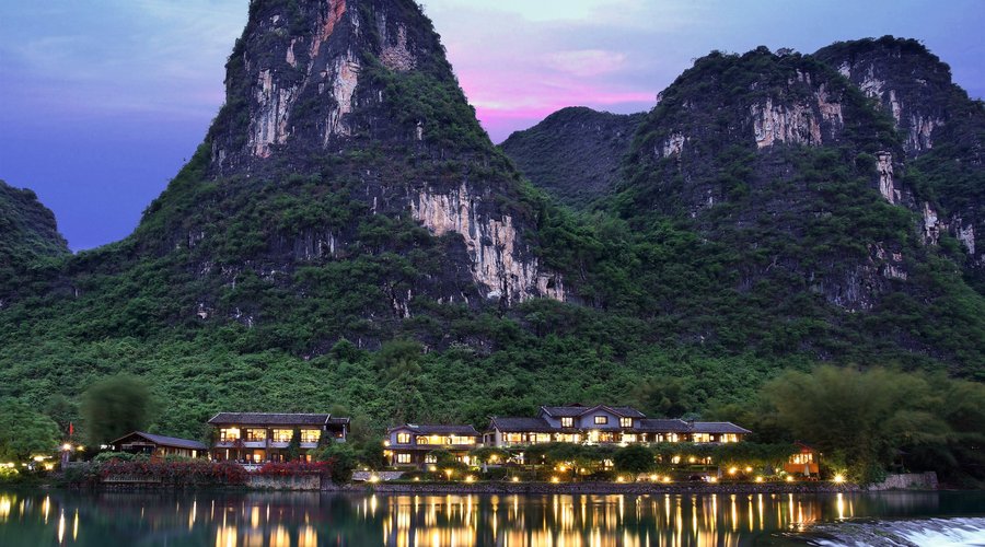 View of Yangshuo Mountain Retreat at dusk from across the Yulong River, Yangshuo China
https://www.yangshuomountainretreat.com