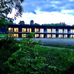 Hotel Außenansicht mit Balkonen/Terrassen vom Wald aus gesehen