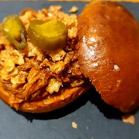 Pan de hamburguesa tipo viena relleno de ropa vieja, cebolla frita y jalapeños
