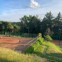 Campi da tennis in terra rossa in mezzo al verde sulle colline del Chianti.
