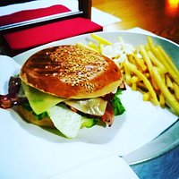 Saboroso pão com sementes de sésamo, hambúrguer grelhado, bacon estaladiço, queijo derretido, ovo, salada e maionese.