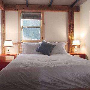Our three cozy wood cabins each feature a queen-sized bedroom and a rustic living space with comfy seating, television, wifi , kitchenette and covered front porch.
