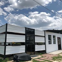 From the rear/parking area. There's a covered patio with side slats allowing air flow on warmer days.