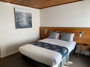 Port Campbell Motor Inn in Port Campbell, image may contain: Interior Design, Indoors, Stained Wood, Bed