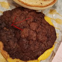 This burger belongs in a burn unit not a restaurant. The arrow points to where the burger is so charged it disintegrated. The rest of the burger looks and smelled like a scab. Forgot one burger in our order so I wasn't upset about it after I saw this one. HORRIBLE!