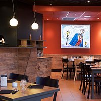 Salle de restaurant, pizzas cuites dans notre four à bois devant le client !