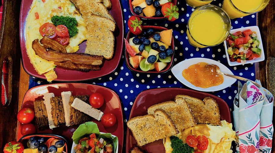 Omelette with bacon, toast, and fruit salad. Lower left was for a vegan and gluten free guest. 