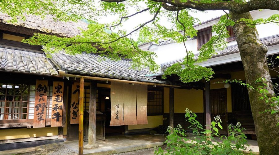 木立の中の大きな茅葺屋根が目印の「山家料理 湯の岳庵」。瑞々しい庭の緑を愉しみながら、舌と目で由布院の旬を堪能いただけます。