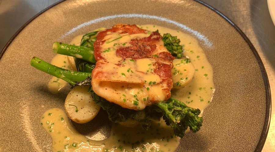 Pan fried fillet of john dory wrapped in serrano ham, charred tenderstem broccoli, char, chive beurre blanc 