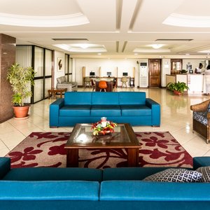 Recepção com confortável lounge e vista para a avenida beira-mar.