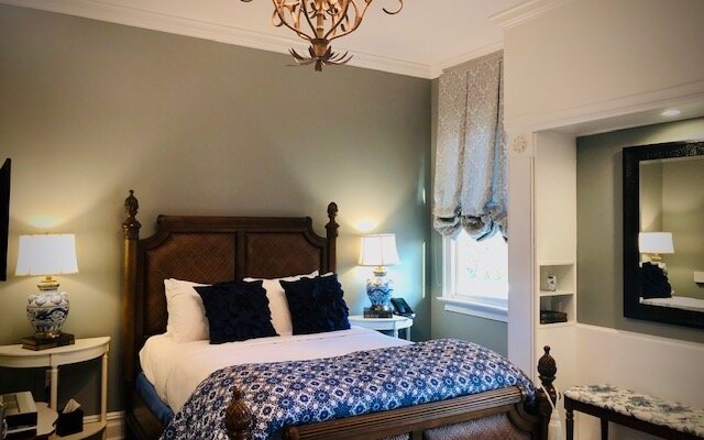 The CLASSIC QUEEN with BALCONY is a beautifully appointed room that is light and airy with a Queen bed, sitting chair and small balcony with table and two chairs.