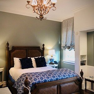 The CLASSIC QUEEN with BALCONY is a beautifully appointed room that is light and airy with a Queen bed, sitting chair and small balcony with table and two chairs.