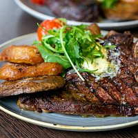 14oz T-bone steak, served with triple cooked chips, confit vine tomato, grilled flat cup mushroom and homemade onion rings