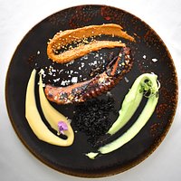 Pulpo a la brasa sobre arroz negro y 3 salsas