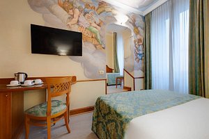 Amalfi Hotel in Rome, image may contain: Monitor, Screen, Bed, Chair