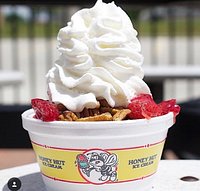 A strawberry sundae with pecans and extra whipped cream