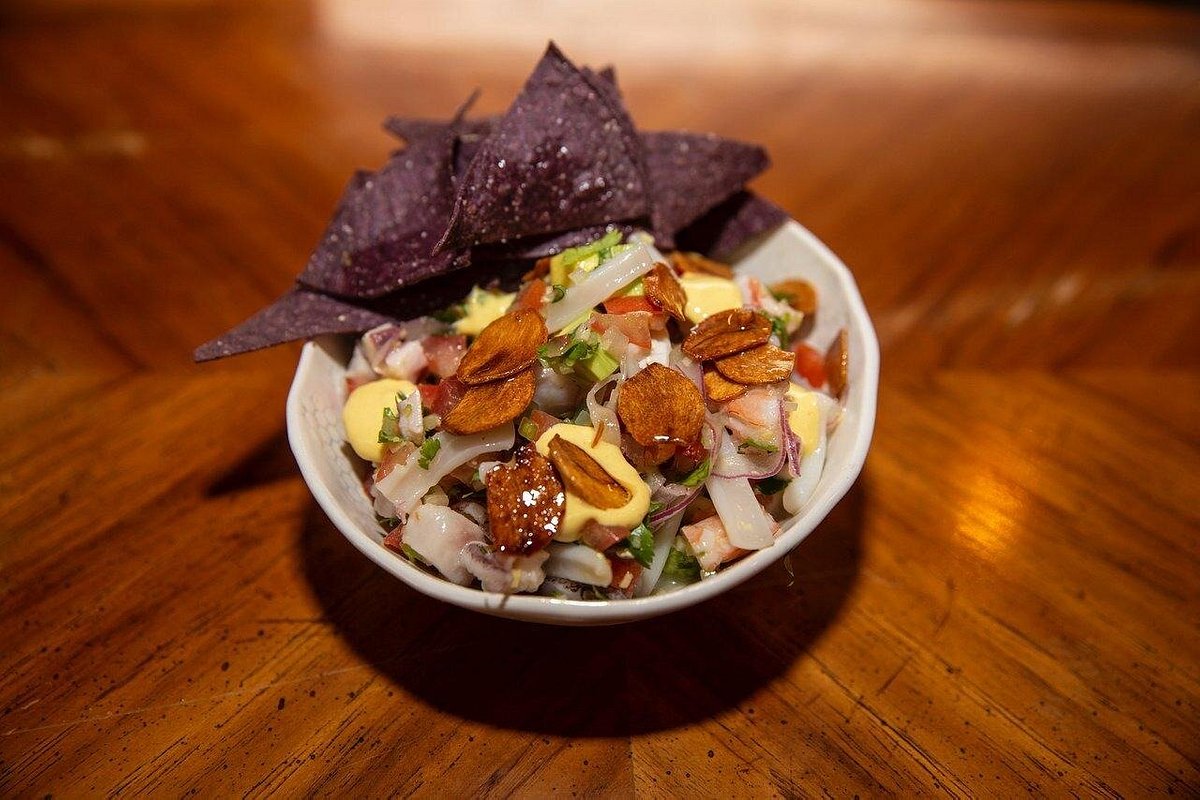 Bowl of ceviche served with blue corn chips.