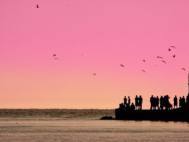 People gathered on the pier to watch the sunset in Grand Haven.
