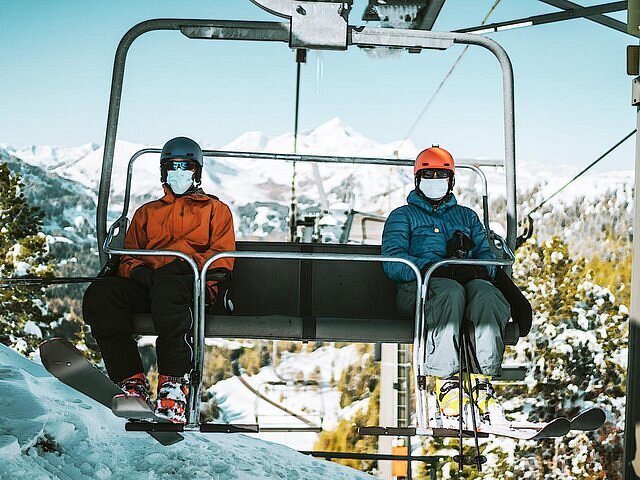 A ski lift running people up and down a snow-covered mountain.