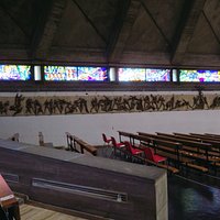 La via crucis in bronzo senza soluzione di continuità tra le varie scene (posta alla sx del presbiterio)