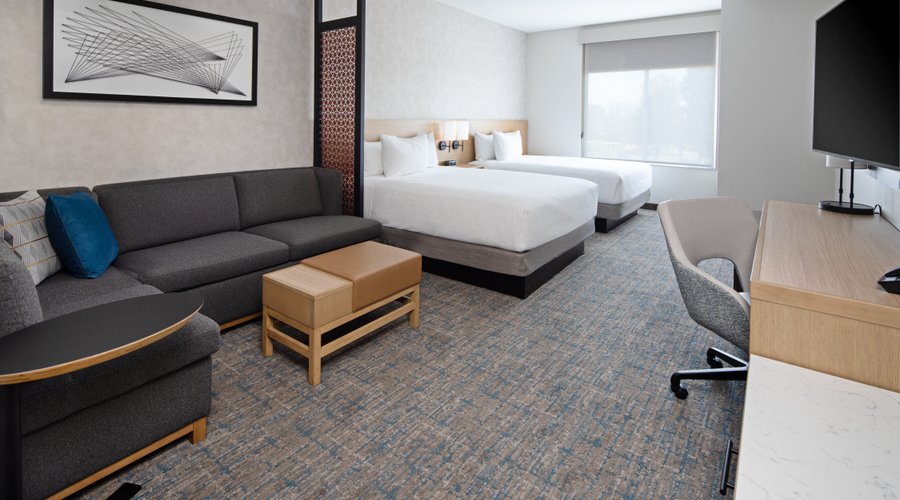 Relax in this 252-sq ft two queen bed room with a work desk, and a Cozy Corner with a sofa-sleeper