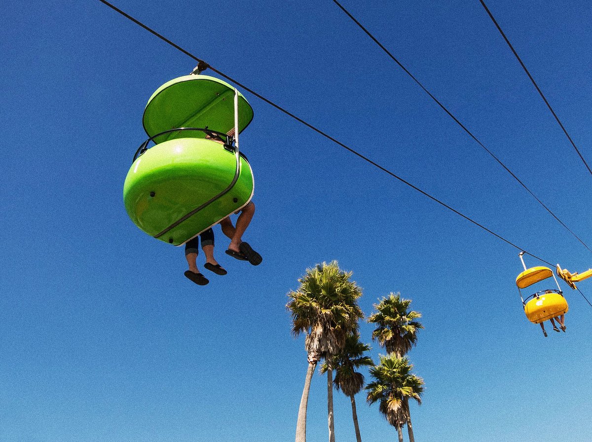 People riding a gondola against a blue sky