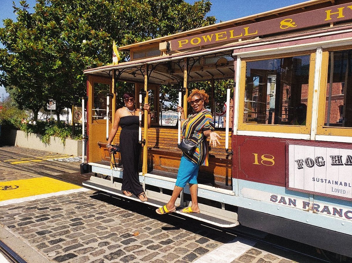 Two women are posing on a trolley