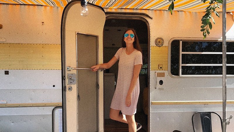 Photo of Ashley Rossi, stepping out of an RV