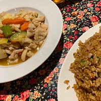 Sizzling Mongolian lamb and chicken with plum sauce with a small bowl of fried rice.